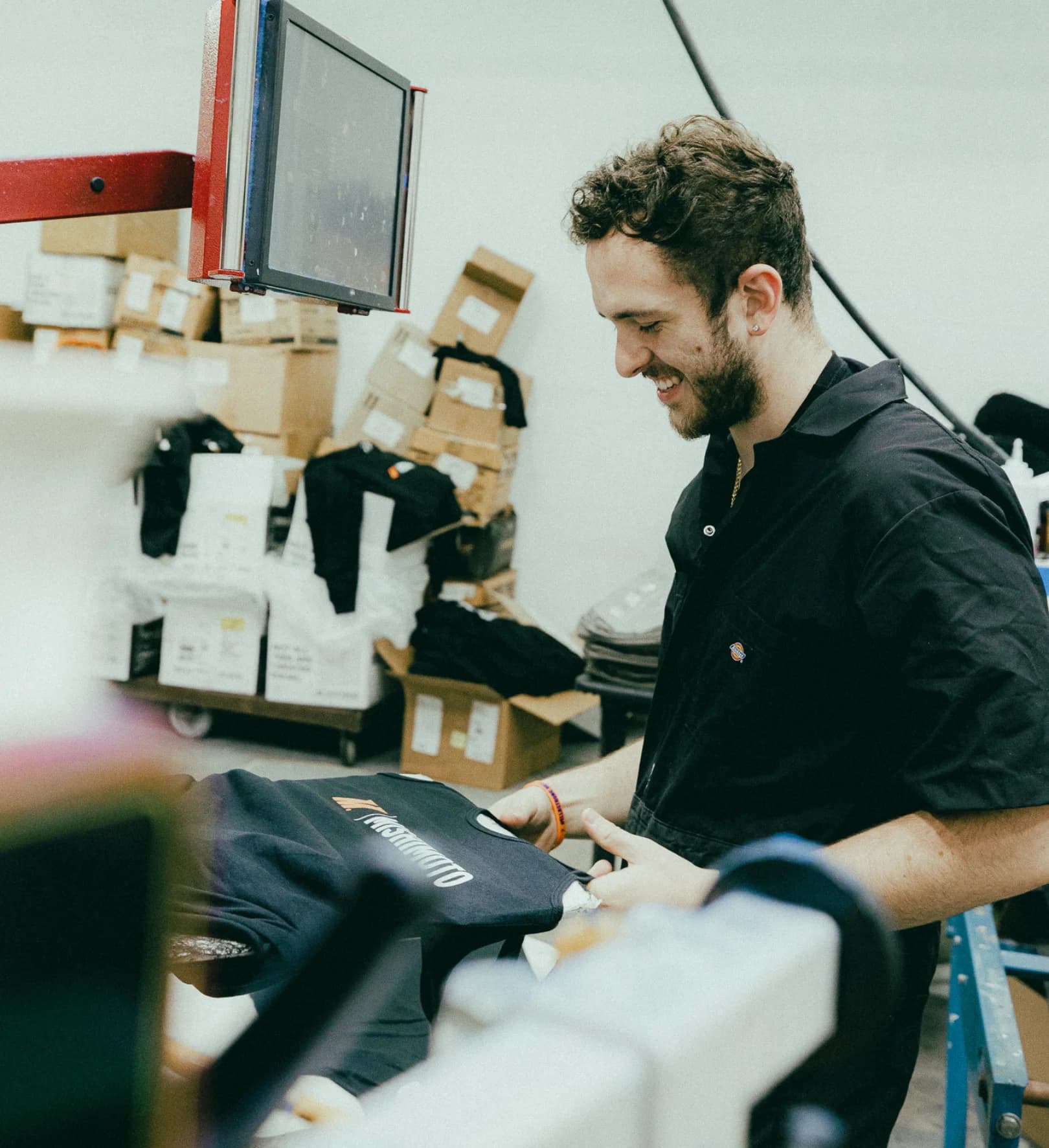 Tee Vision employee operating a screen-printing press